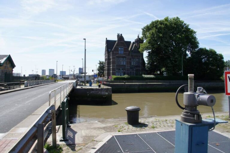Zicht op de sluis bij het water met de Stad in de verte.