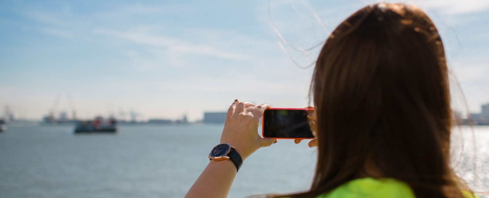 Tijdens een haventour maakt een studente hoger onderwijs foto’s met haar smartphone van de haven in actie. © Jesse Willems