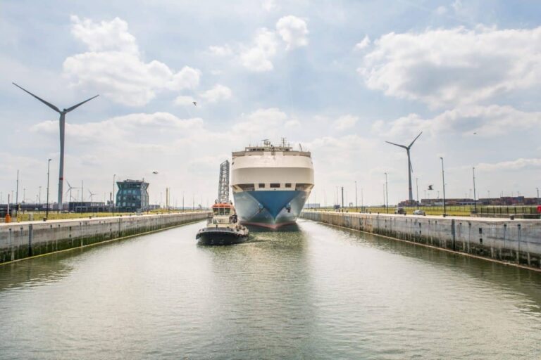 Zicht op de Kieldrechtsluis en een autoschip dat getrokken wordt door een sleepboot.