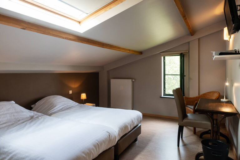 B&B kamer met een tweepersoonsbed, een tafel en een stoel