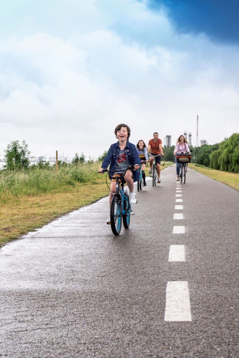 Kleine jongen met gezin aan het fietsen door de haven