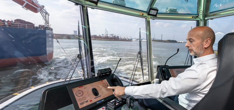 Sleepbootkapitein achter het roer van een sleepboot.