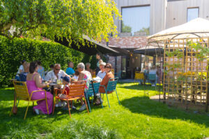 groep mensen zittend aan tafel in een groene tuin