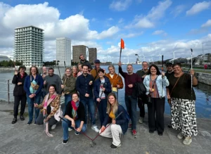 groep van 20 personen aan rand van Kattendijkdok, met zicht dok en woontorens